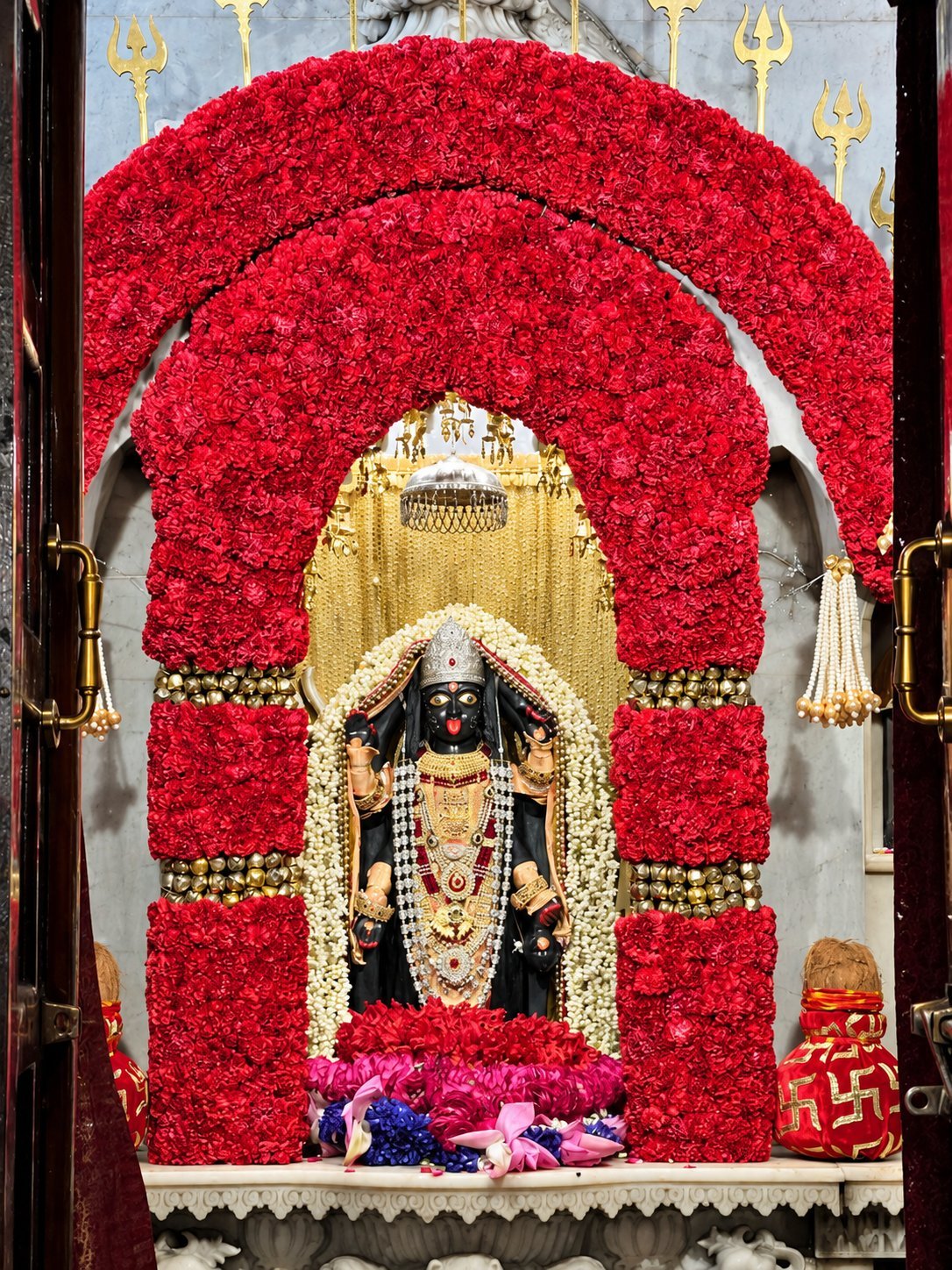 Maa Kali shrine framed by red rose arches