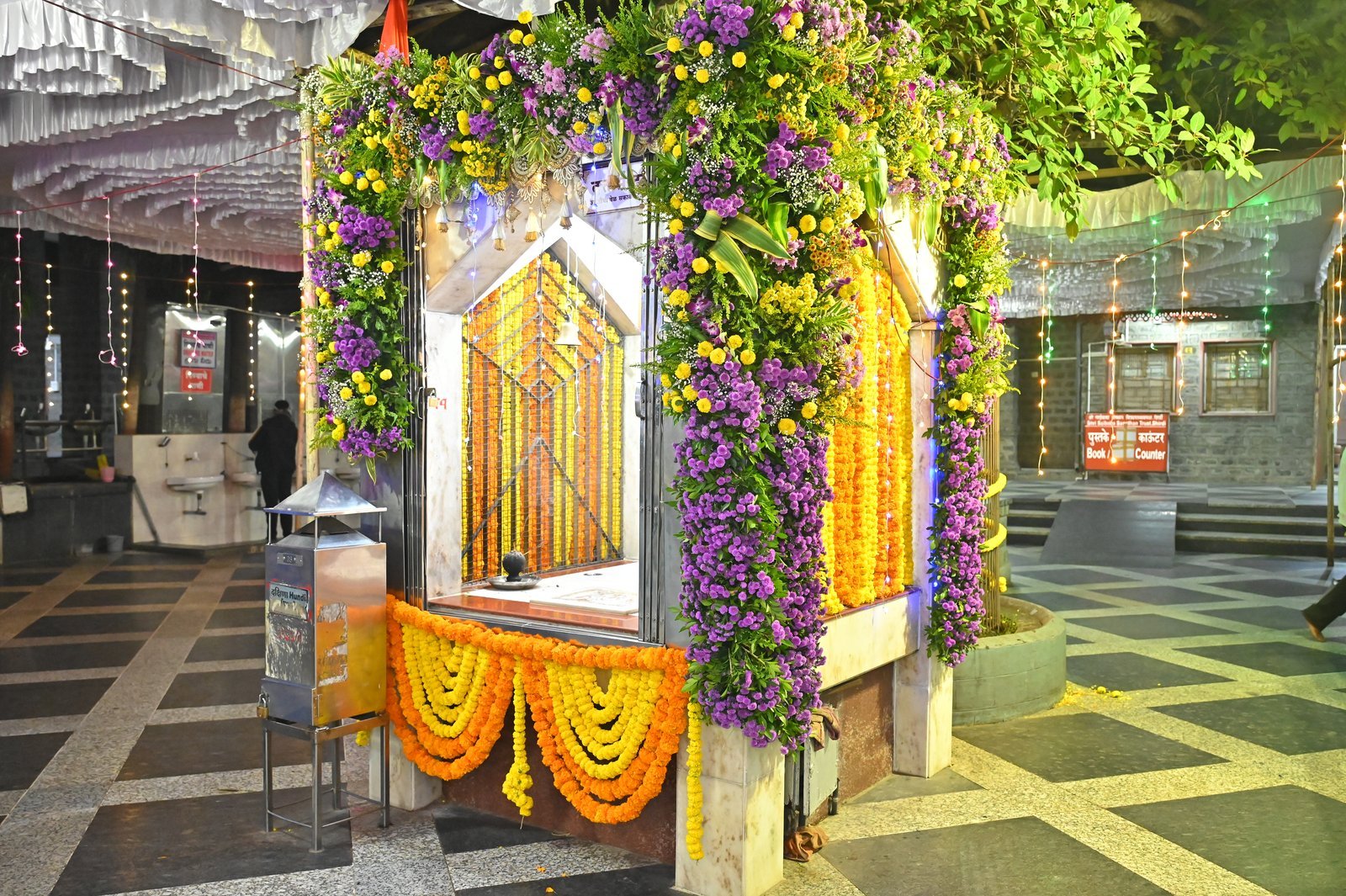 Shirdi shrine framed in purple and yellow flowers