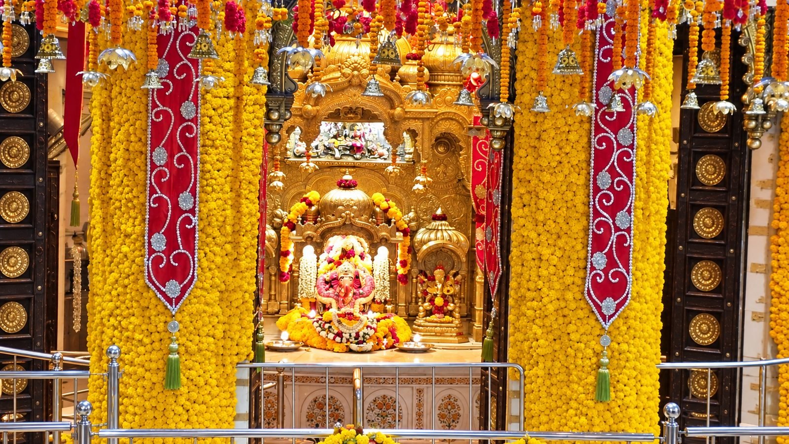 Ganesh murti framed by marigold pillars at Shree Siddhivinayak Temple