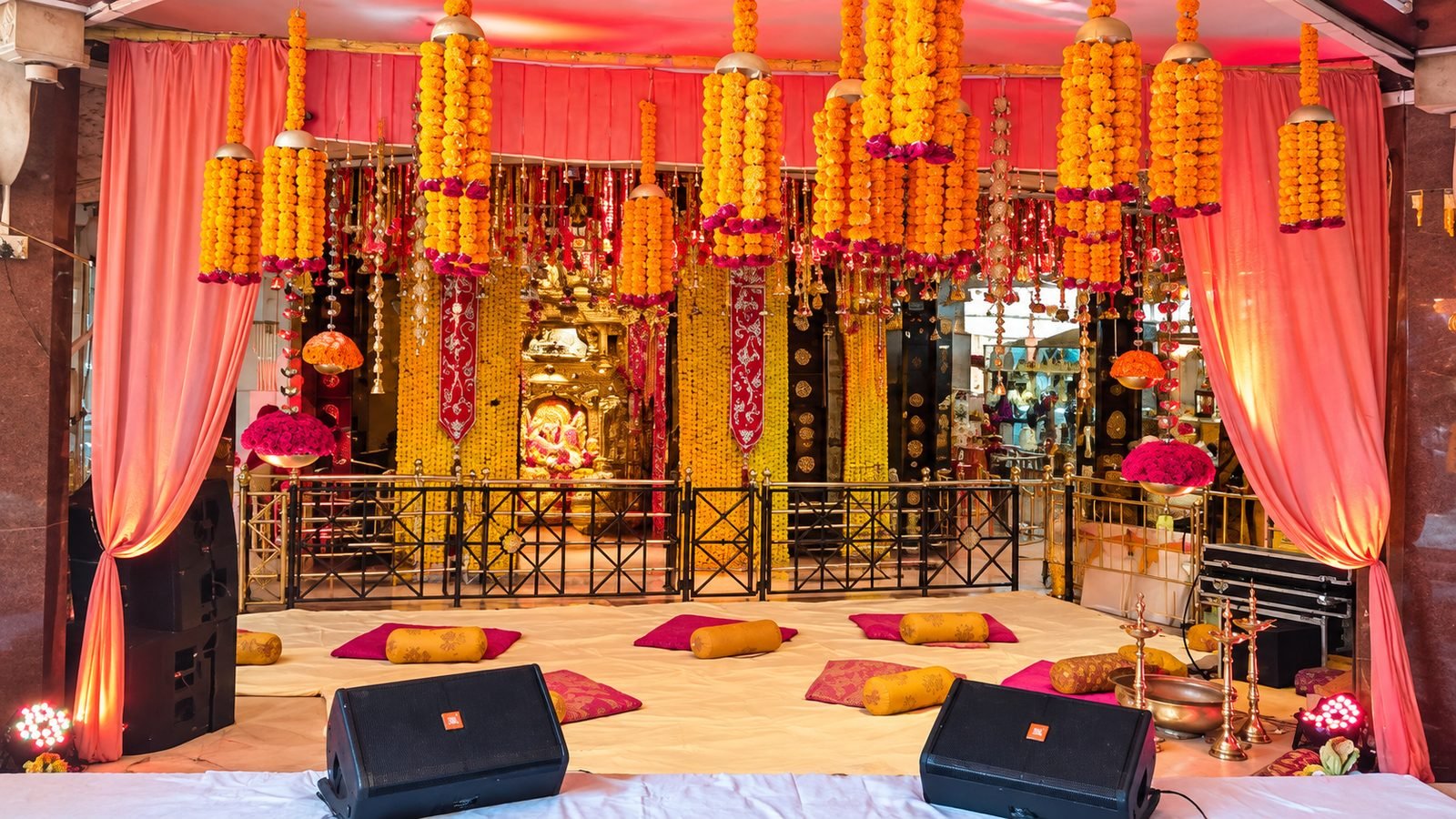 Hall dressed with hanging marigold strings and stage at Siddhivinayak