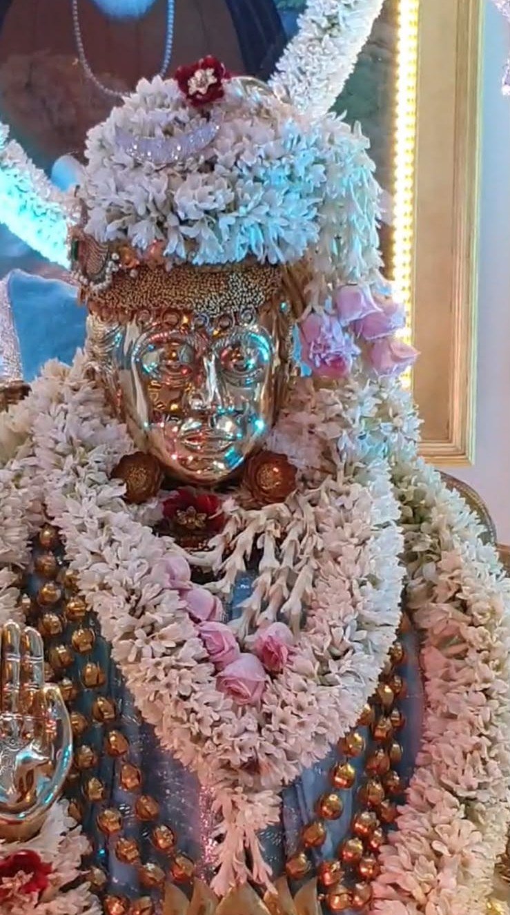 Deity adorned in white floral shringar at Guruji Ashram Bada Mandir