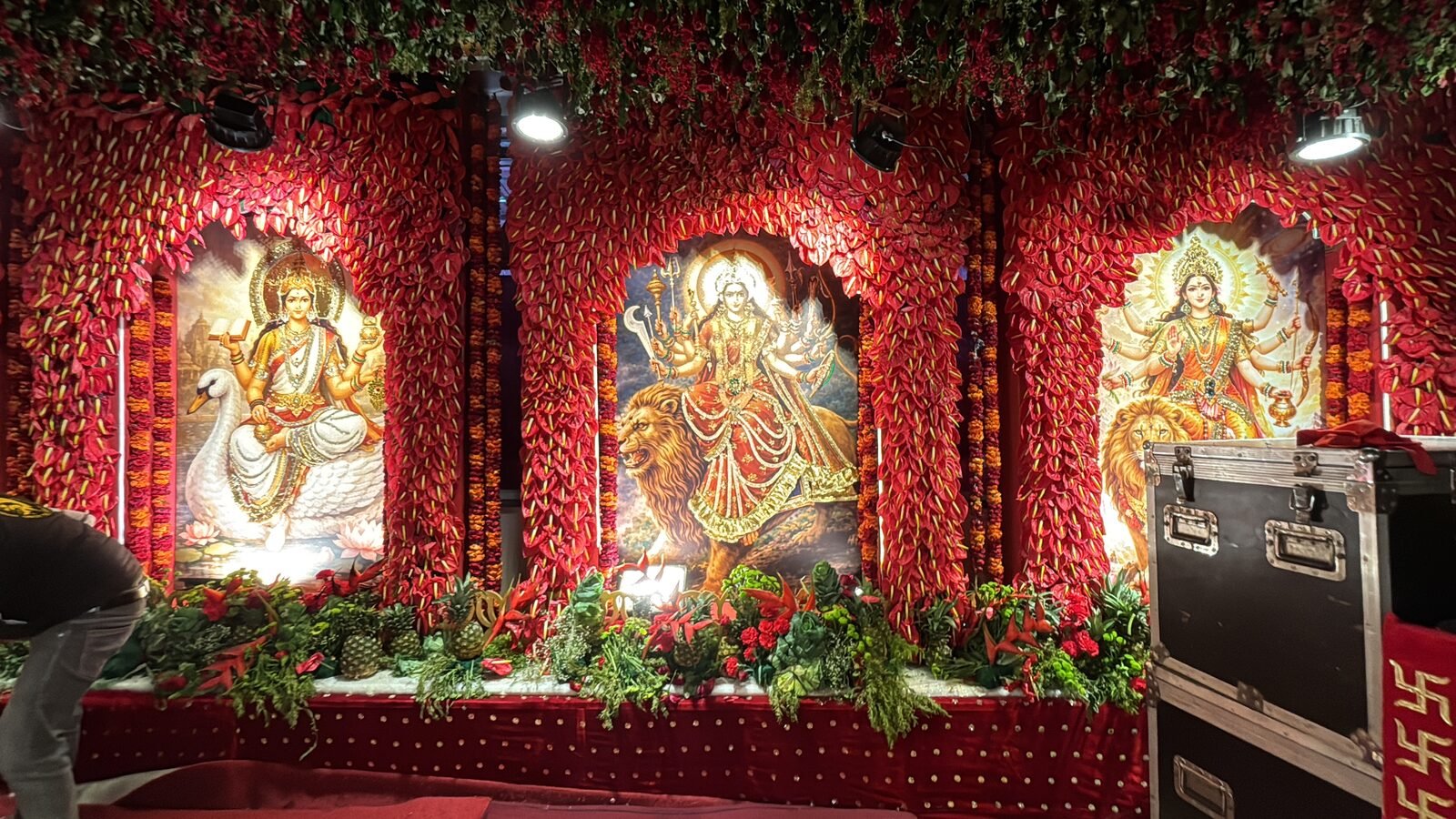 Deity panels framed in red floral arches at Maa Vaishno Devi Shrine