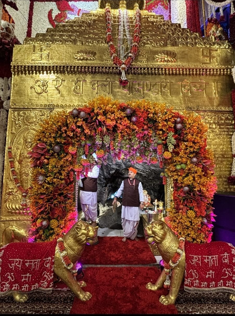 Golden gufa darshan framed by floral torans at Maa Vaishno Devi Shrine