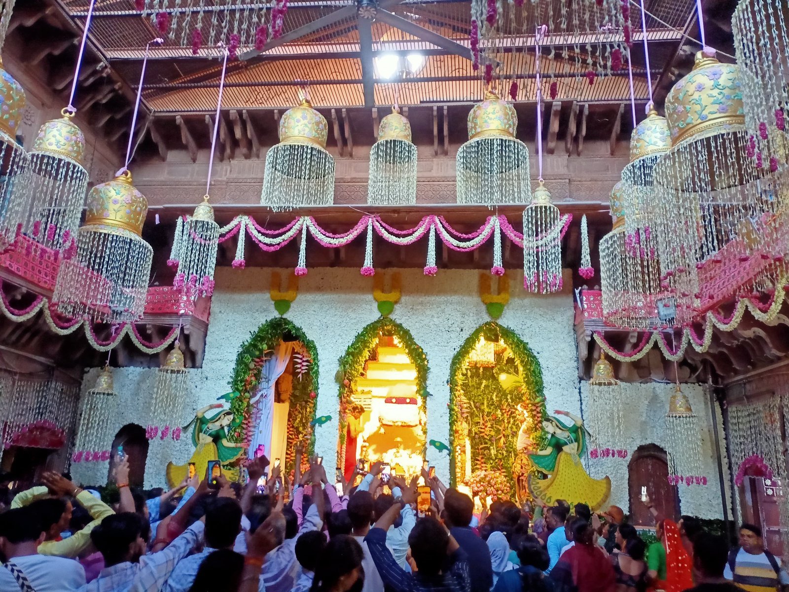 Devotees gathered for darshan in a flower-filled Vrindavan temple